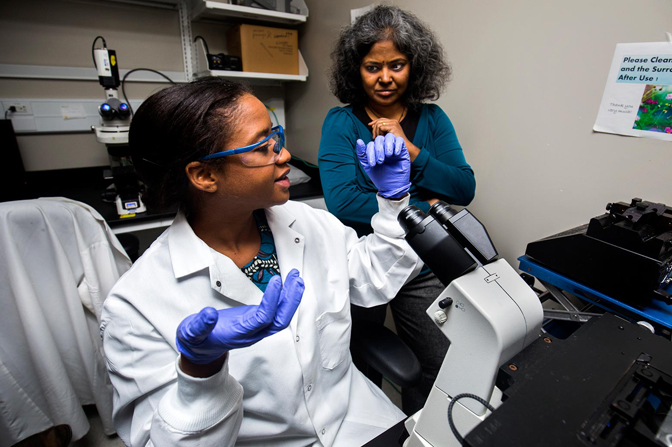 Women discussing results of cell analysis.