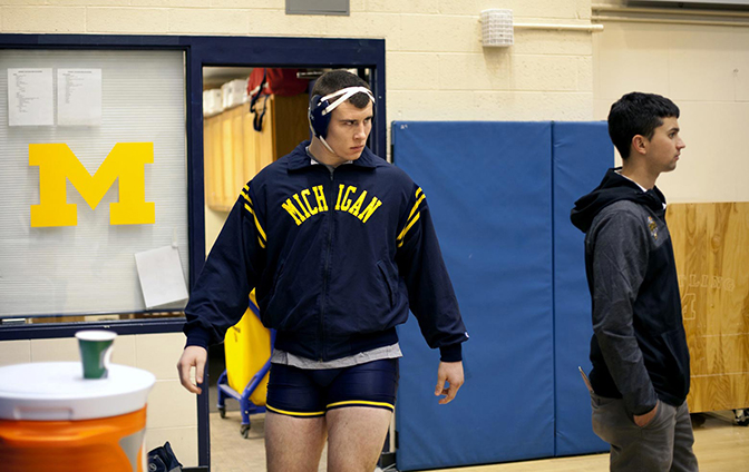 A person in wrestling gear inside a gym.