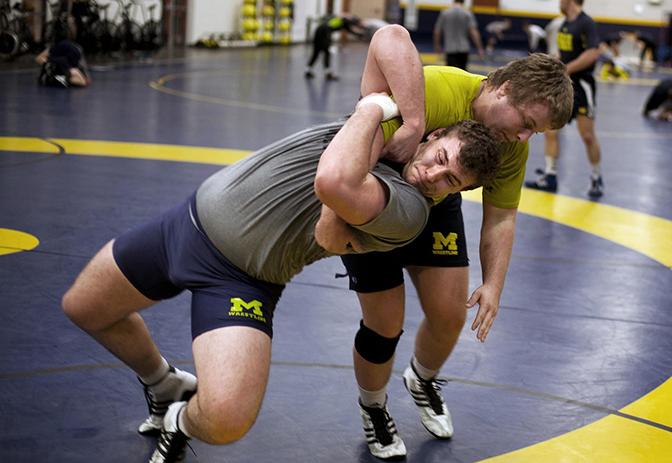 Two people practicing wrestling each other.