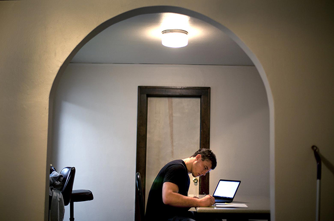 A person sitting at a table working on a laptop.