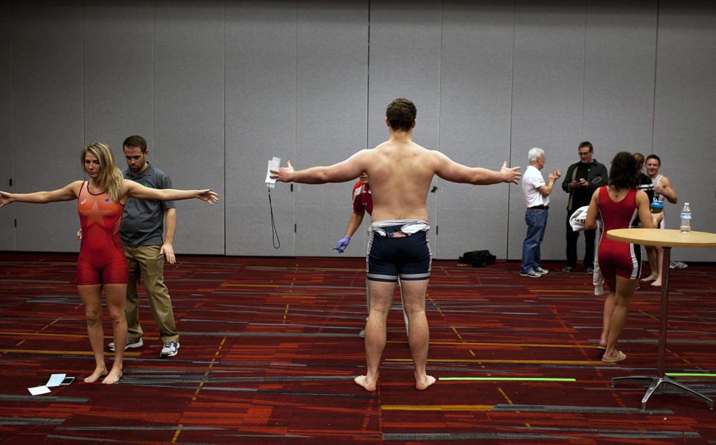 Several people standing in a room with their arms extended.