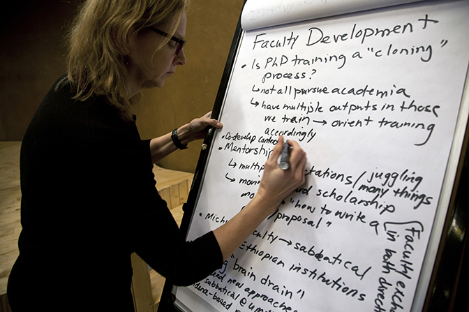 Image of Nancy Love taking notes on a paper board during the EMPACE symposium