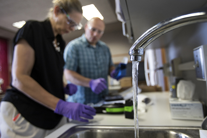 Nancy Love calibrating a test instrument with her collaborator Shawn McElmurry