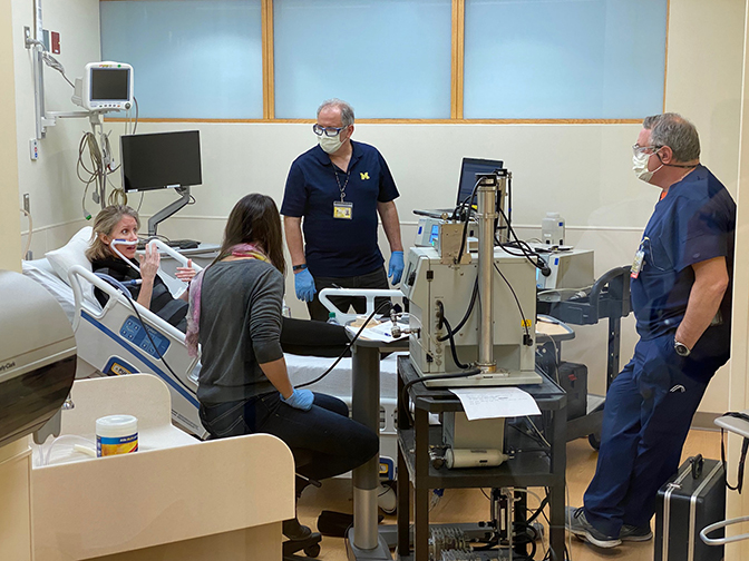 Image of Amy Cohn acting as a test patient during experiments to see how aerosols flow from nasal cannula within a simulated hospital setting