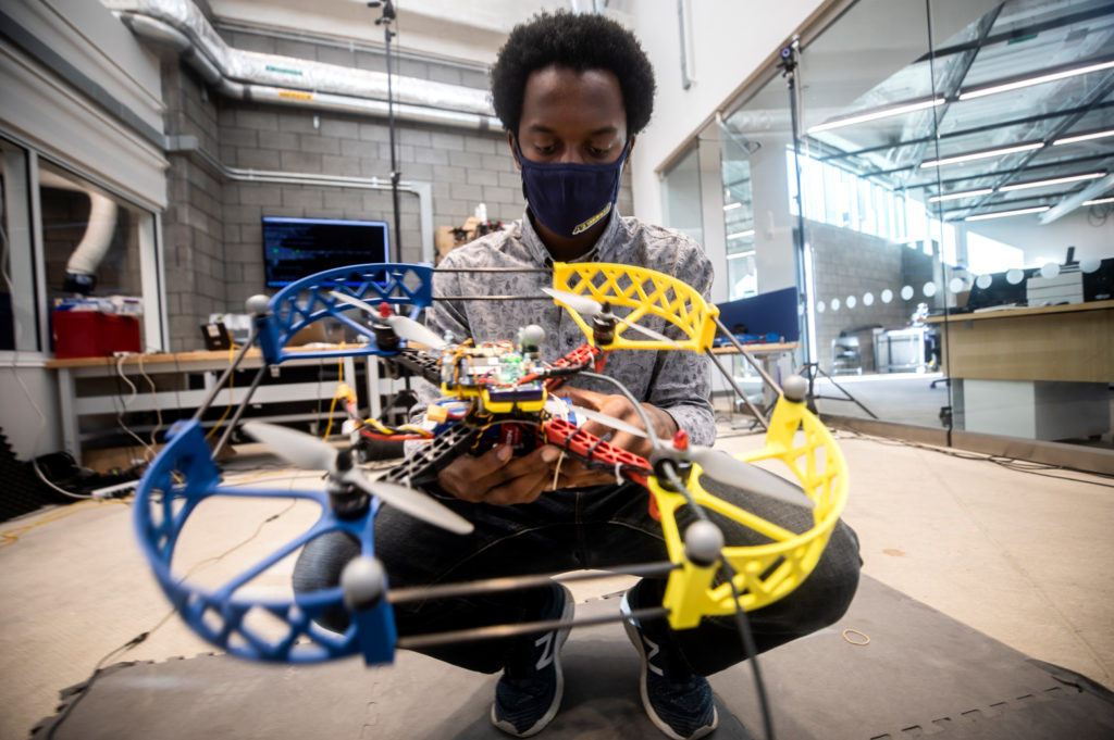 Prince Kuevor, Robotics PhD Student, changes a battery on a drone in the Fly Lab in the Ford Robotics Building. Photo: Joseph Xu/Michigan Engineering, Communications and Marketing