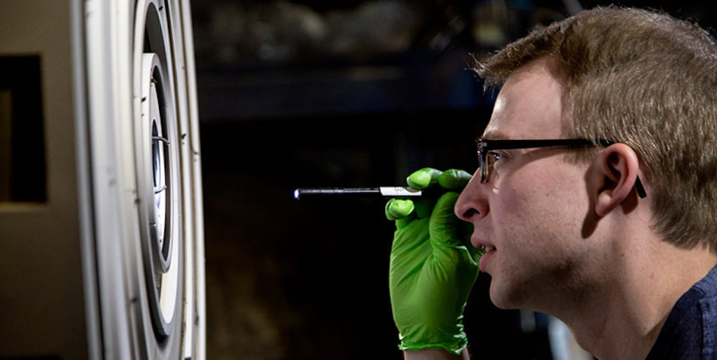 Scott Hall, AERO PhD student, checks on the X3 thruster after a test run in the Plasmadynamics & Electric Propulsion Laboratory.