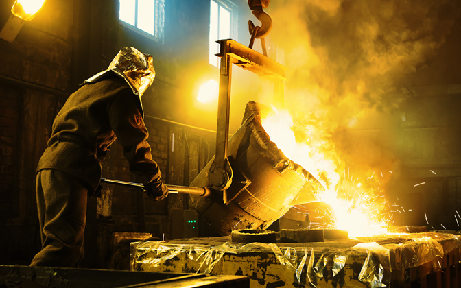 A worker pours liquid metal