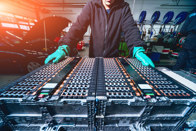 Person standing over batteries that will go inside an electric vehicle