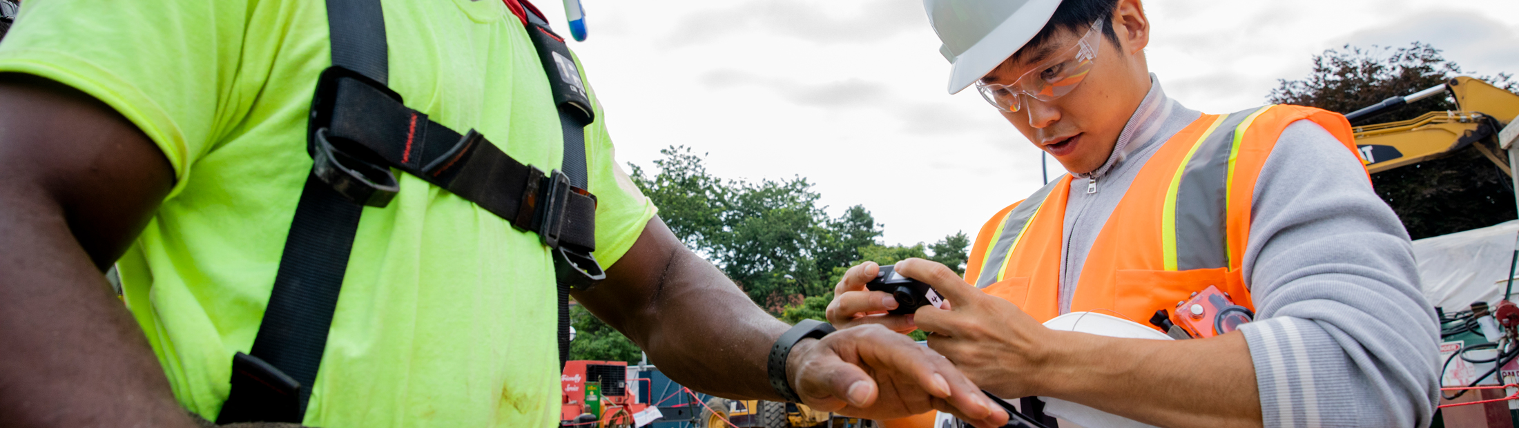 A researcher puts a heartbeat monitor on a construction worker