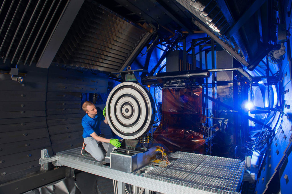 Scott Hall, former doctoral student in aerospace engineering at the University of Michigan, adjusts the record-setting X3 thruster at NASA Glenn Research Center in 2017. Credit: NASA