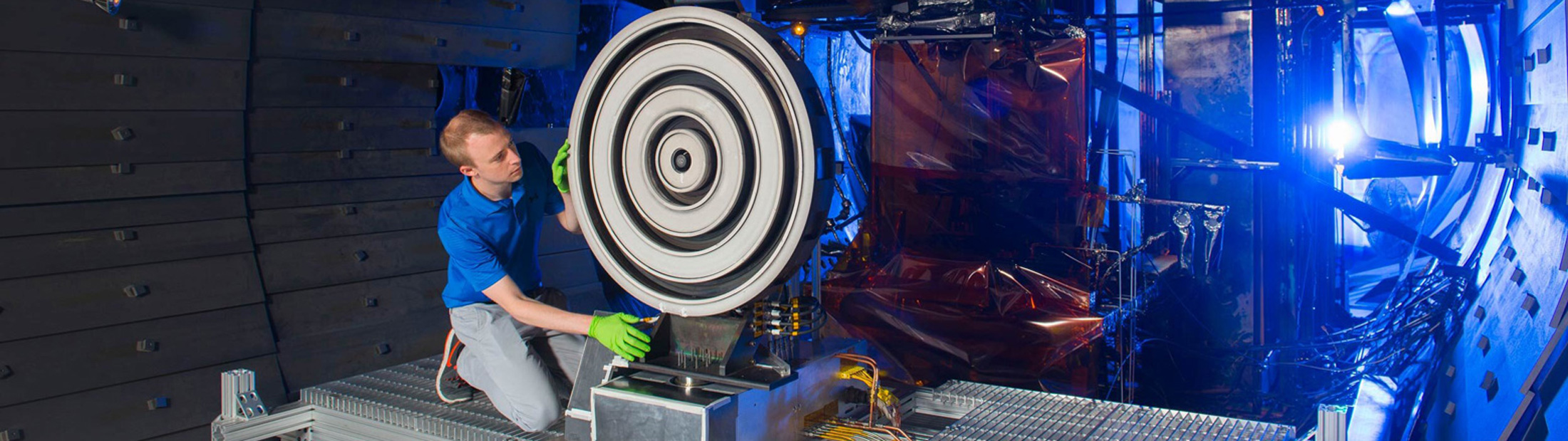 Scott Hall, former doctoral student in aerospace engineering at the University of Michigan, adjusts the record-setting X3 thruster at NASA Glenn Research Center in 2017. Credit: NASA
