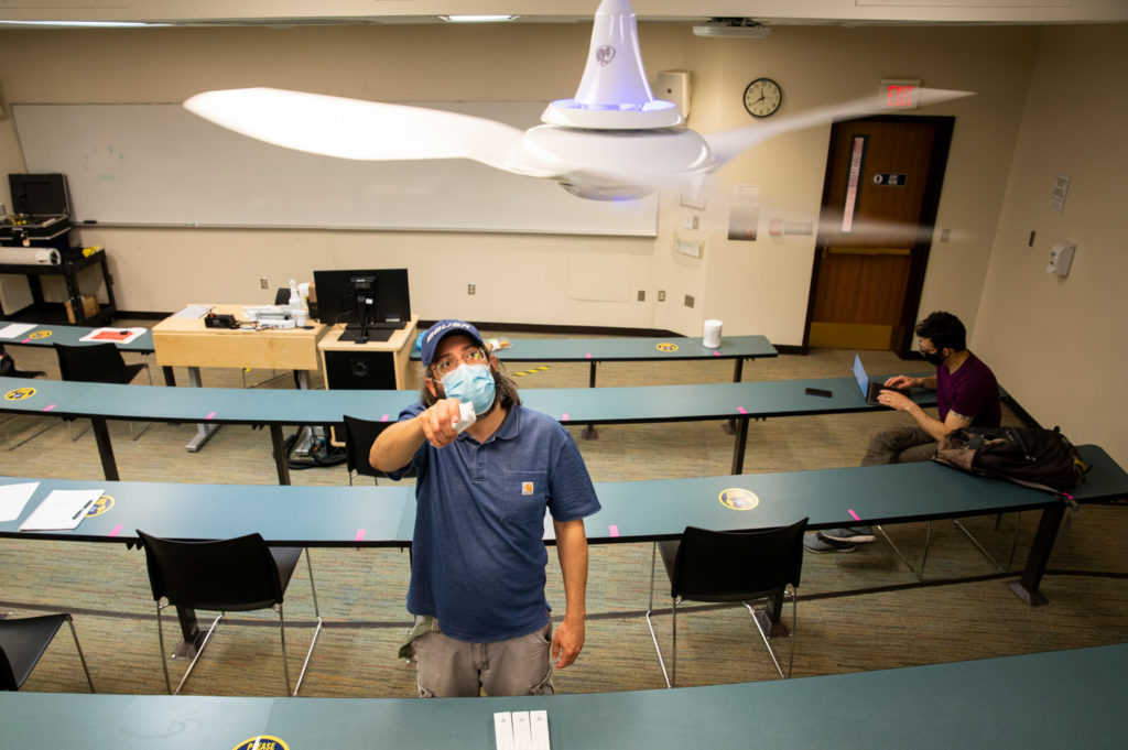 Mechanical Engineering Research Fellow Robert Middleton adjusts UV-equipped fans as part of a study on how various mitigation measures affect airflow in classrooms.. Photo: Robert Coelius/Michigan Engineering