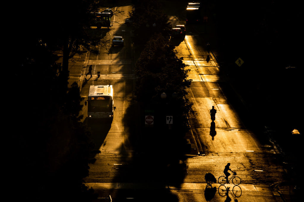 A bus and bicycle on a road at twilight