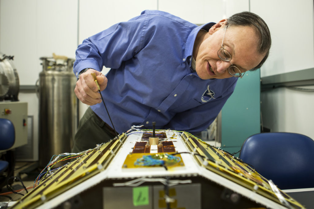 Frederick Bartman Collegiate Professor of Climate and Space Science, Chris Ruf, inspects one of the CYGNSS satellites in the Space Research Laboratory in the Space Research Building on North Campus of the University of Michigan.