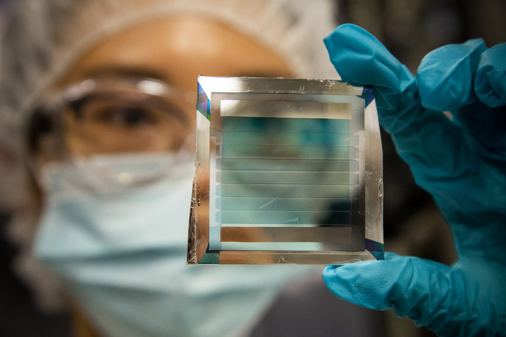 A person holding up a solar cell