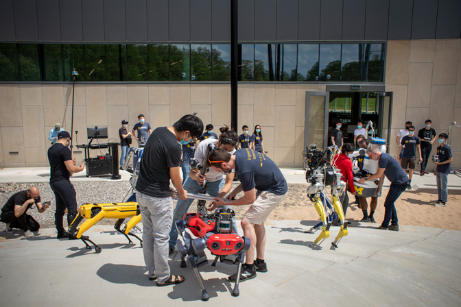 Humans working on robotics outside the Ford Robotics Building