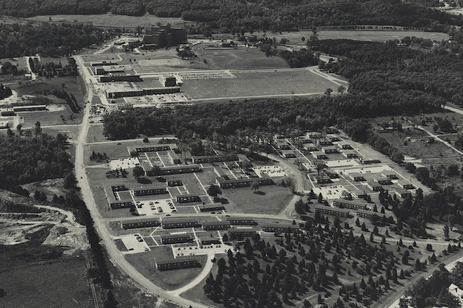 Black and white aerial view of buildings with trees.