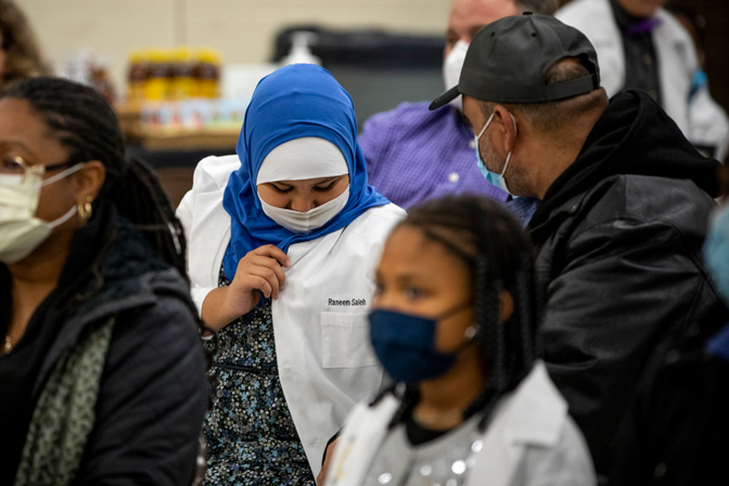 Raneem Saleh admires her lab coat at the Grizzly Scholars kick-off ceremony on November 11th.