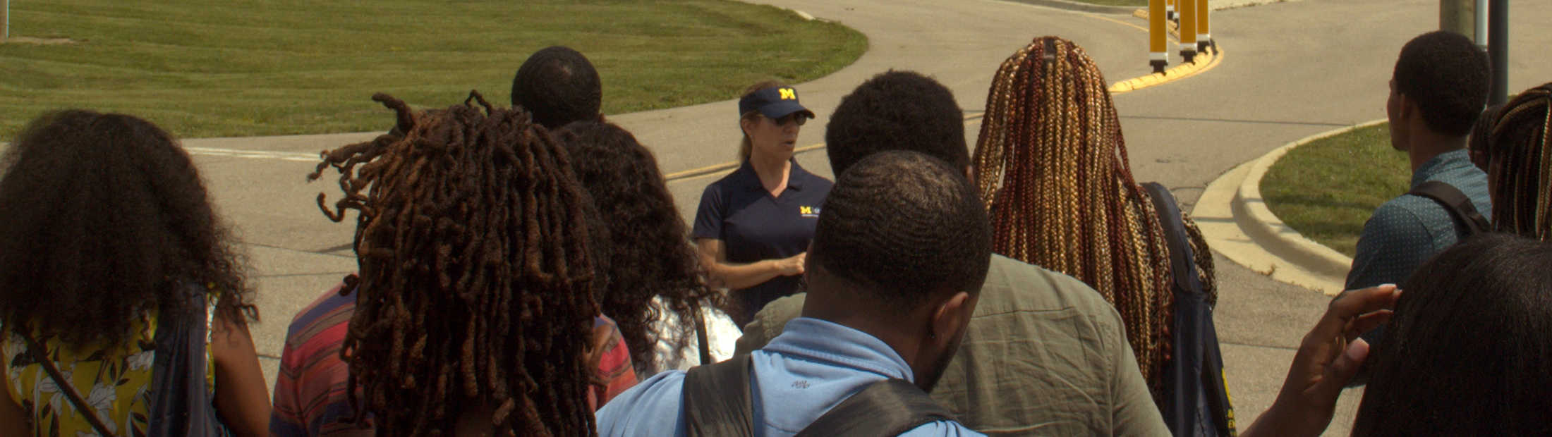 Tour guide talking to group of students at autonomous vehicle test facility