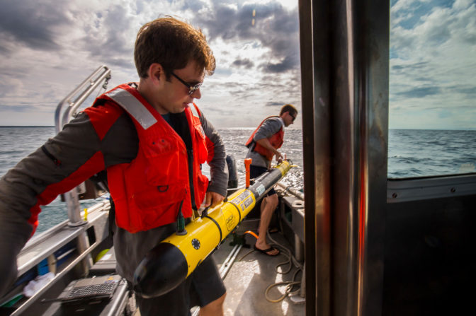 Gideon Billings, Robotics PhD student, and Nick Goumas, research and development engineer, both with the DROP Lab, test an underwater robot on the Great Lakes. Photo: Robert Coelius/Michigan Engineering