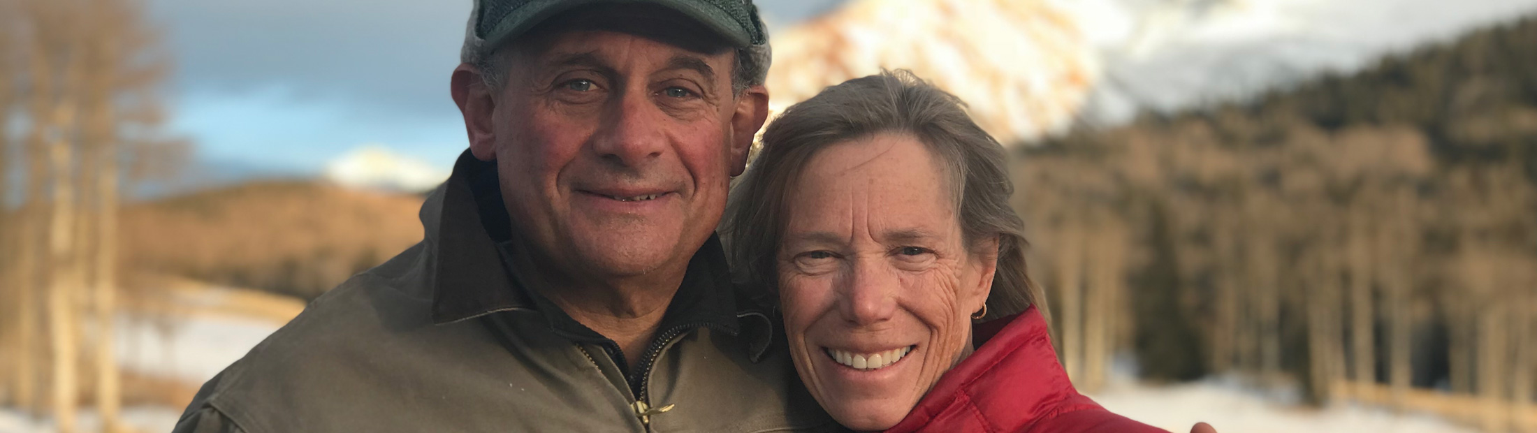 Dan and Sheryl Tishman standing in a valley at the base of a mountain