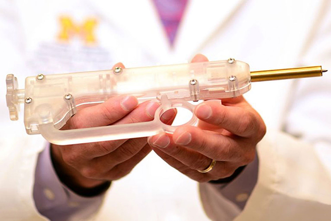 A pair of hands holding a tool made from clear plastic and metal.