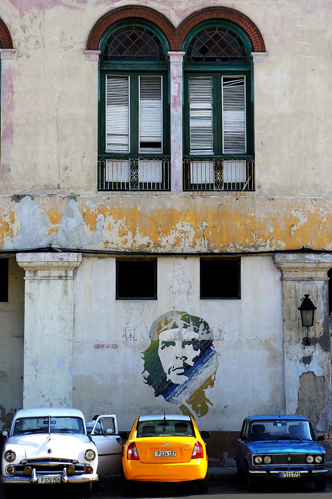 The side of an old building with Che Guevara's face pained on it.