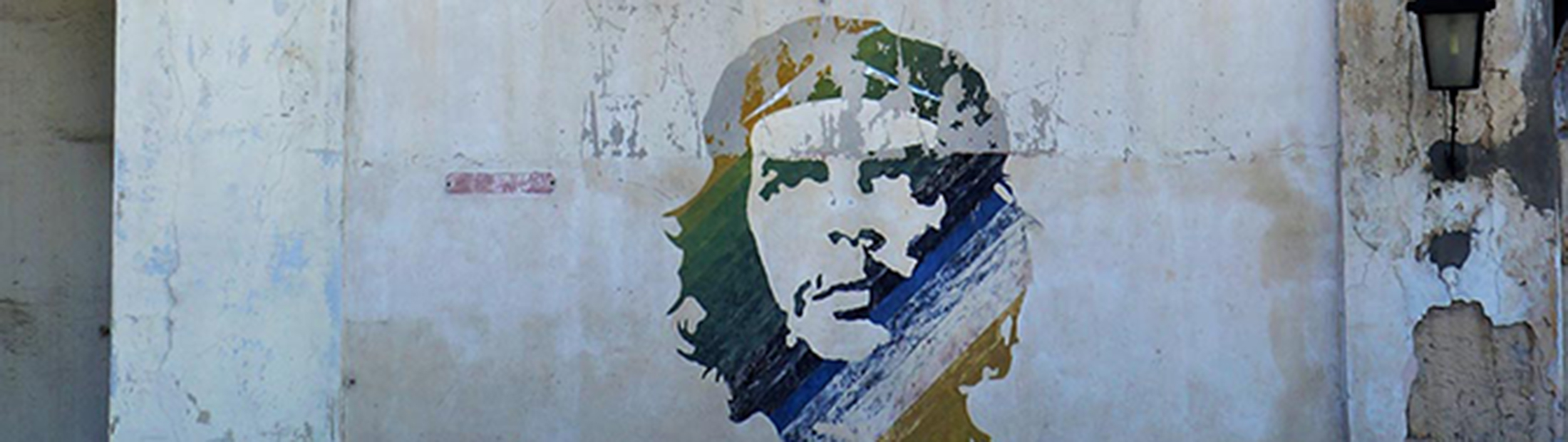 The side of an old building with Che Guevara's face pained on it.