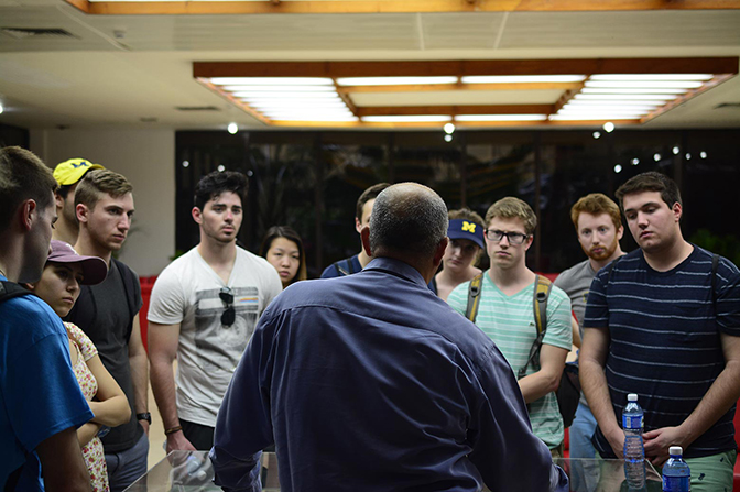A group of people listening to one man speak.