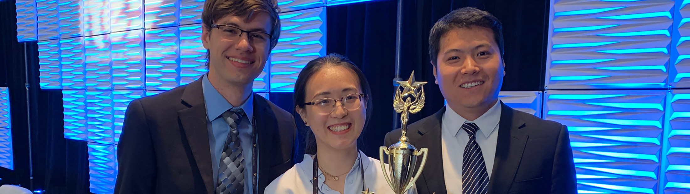 Group image of U-M team members Alex Sundt, Xiatong Sun and Yan Zhao with their trophy