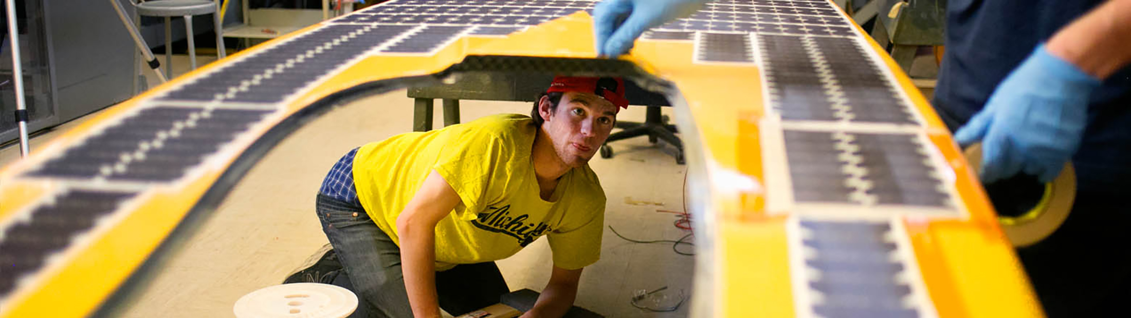 Image of team members carefully installing solar cells on the array canopy