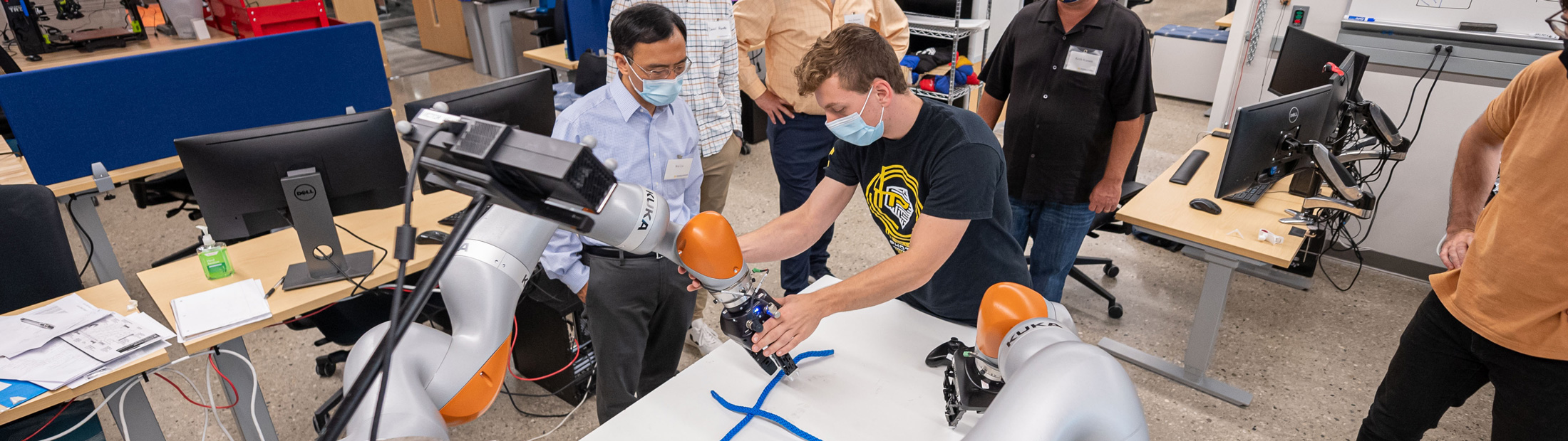 Peter Mitrano working with the robot as it handles the rope