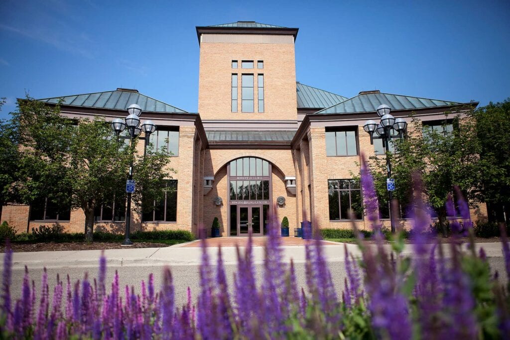 Purple flowers outside the brick Lurie building