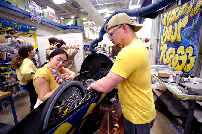 Two students working on a vehicle