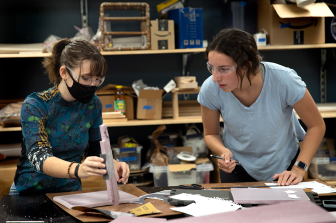 Two women collaborate in the lab with composite material