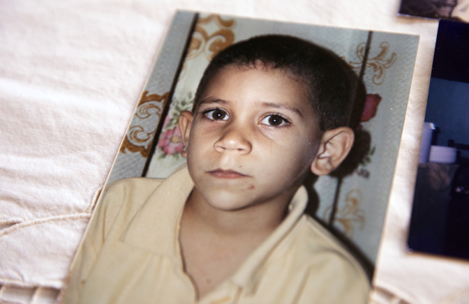 A photograph of Díaz as a child sits on a tablecloth.