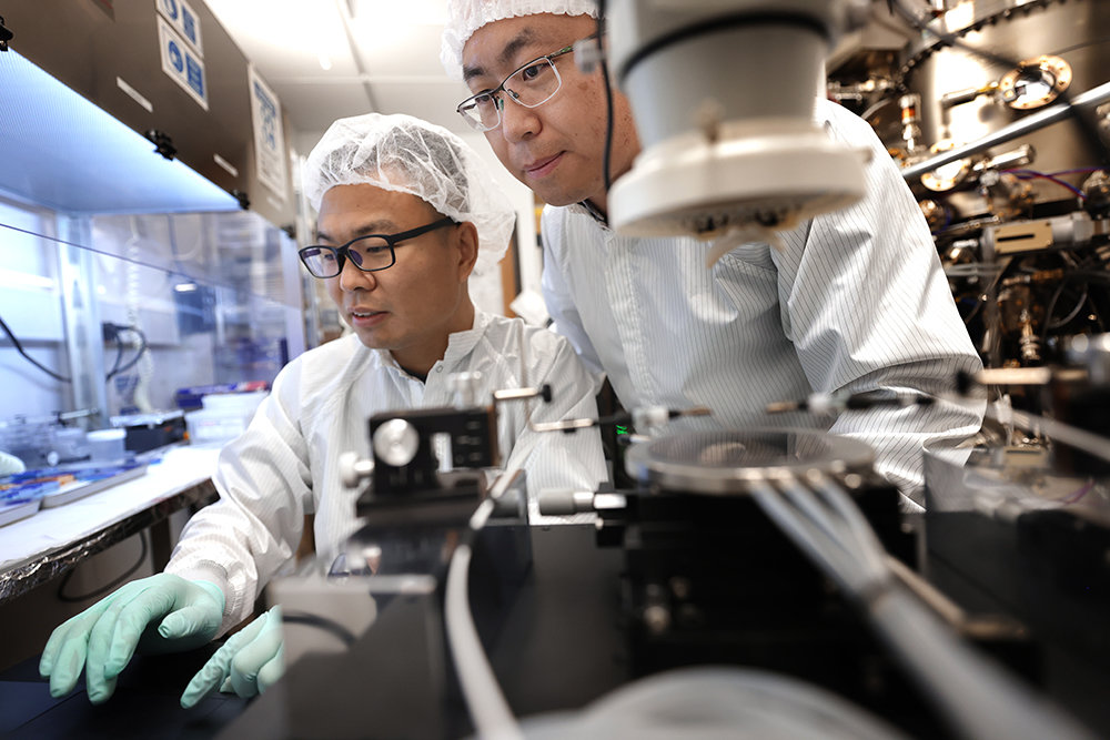two researchers examine a piece of lab equipment