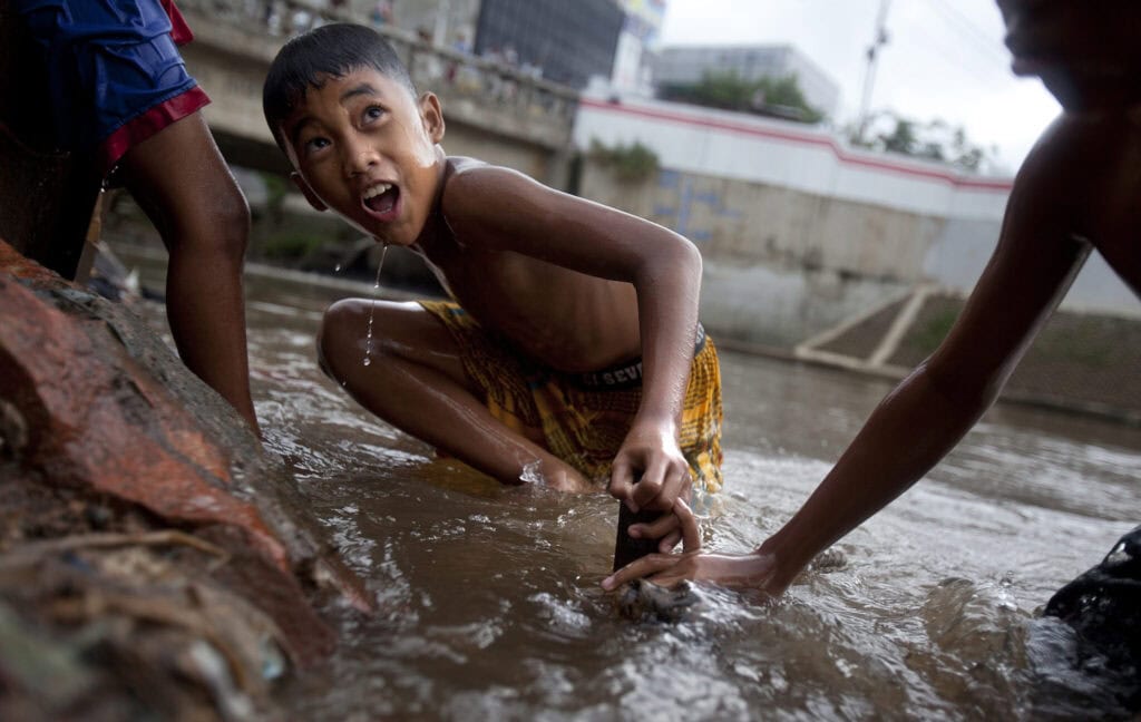 Kids cool off in the Ciliwung River.