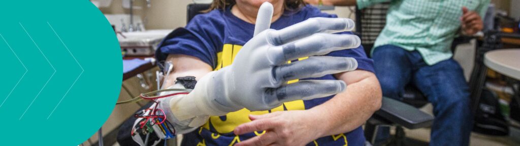 Research participant Karen Sussex performs tests using a computer-operated hand in the lab.