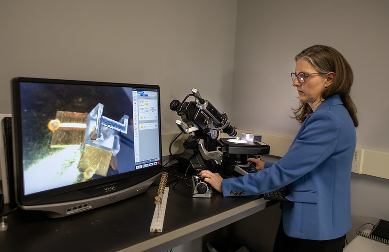 Researcher Carolyn Kuranz stands at a computer and reviews experiment results