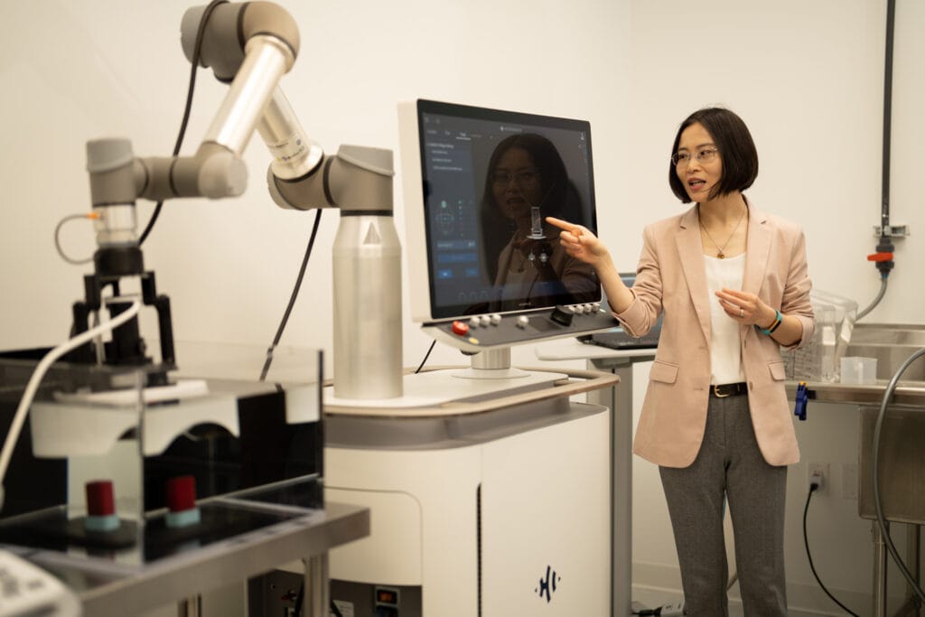 Zhen Xu stands and points at a monitor