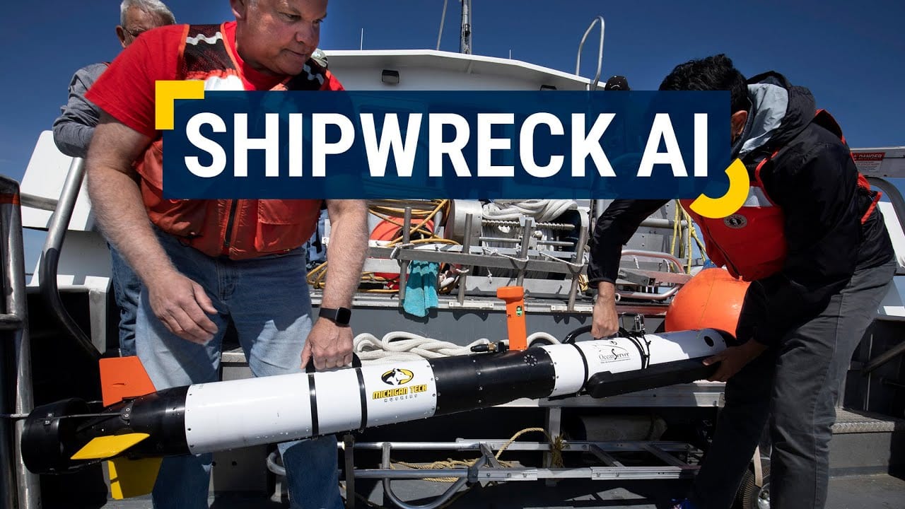 Two men make adjustments to a 6-foot-long robotic submersible on the deck of a boat. The words 'Shipwreck AI' are overlaid on the image, which is linked to a YouTube video about exploring shipwrecks