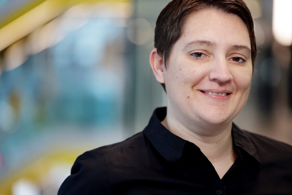 Ann Jeffers smiles in a portrait photo. She's wearing a black button up and has short brown hair.