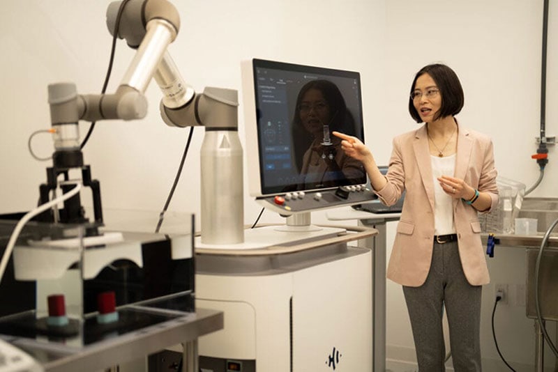 Zhen Xu points to a computer monitor that shows her sample. In the foreground you can see the Edison machine.