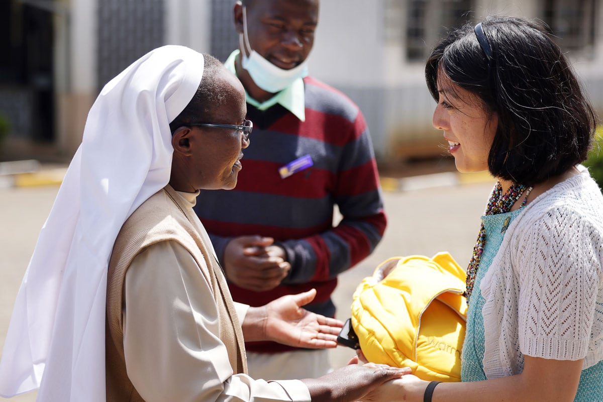 Grace Hsia-Haberl greets Sister Beatrice Clare Osire, at St. Joseph Ombo Mission Hospital in western Kenya, giving her a warming kit.