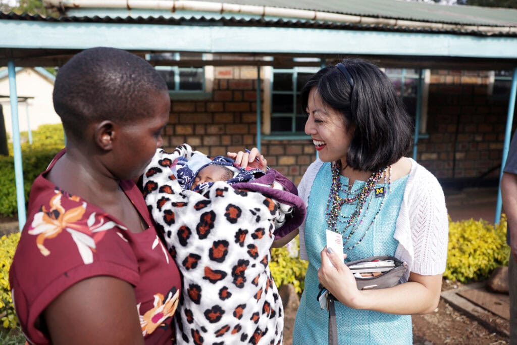 Grace Hsia-Haberl smiles as she meets a mother holding her newborn son outside the Kehancha Sub-County Referral Hospital.