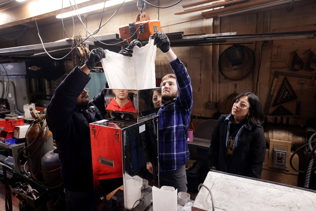 Two students, Ananyo Bhattacharya and Paul Young, insert a substance into a measuring machine in the Warmilu Pack Production Facility.