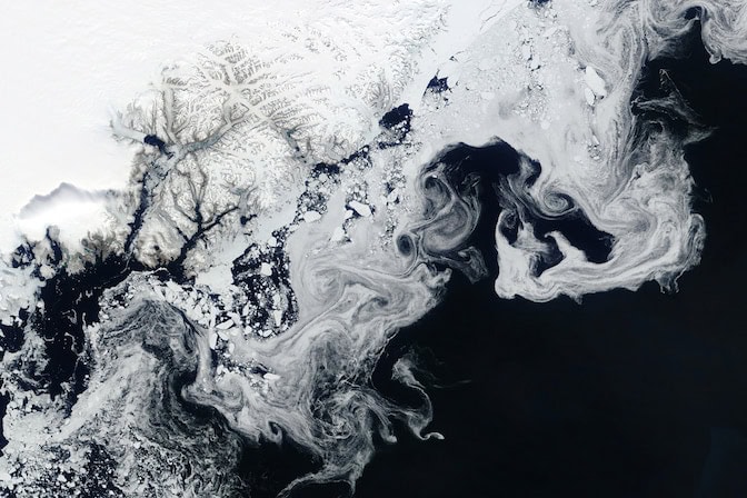 White wisps and spots swirl against the deep blue ocean.