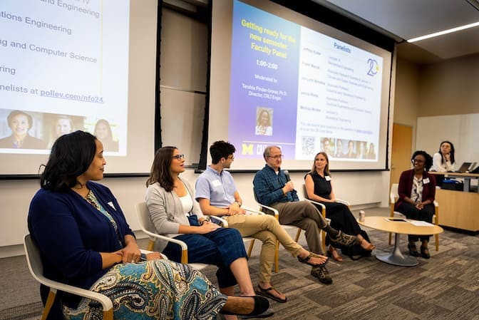 Panel discussion at Michigan Engineering New Faculty Orientation featuring six seated individuals in front of a projected presentation slide.