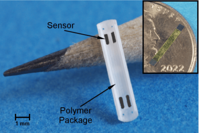 A ridged, rectangular, plastic piece labeled “polymer package” propped up against the tip of a standard pencil, about the same size. An arrow points to “sensor”: four small, film-like rectangles positioned at the plastic piece’s four corners. An inset shows the film-like sensor on a penny, less than half its diameter